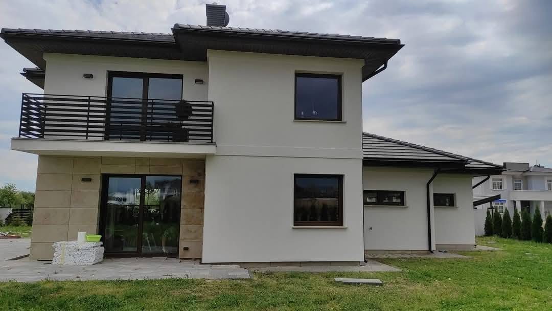 Tylna elewacja nowoczesnego domu z balkonem i jasnym tynkiem
