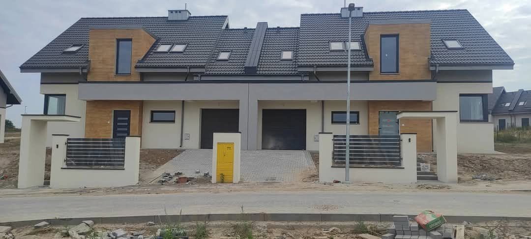 Nowoczesna zabudowa bliźniacza z drewnopodobnymi akcentami i grafitowym dachem