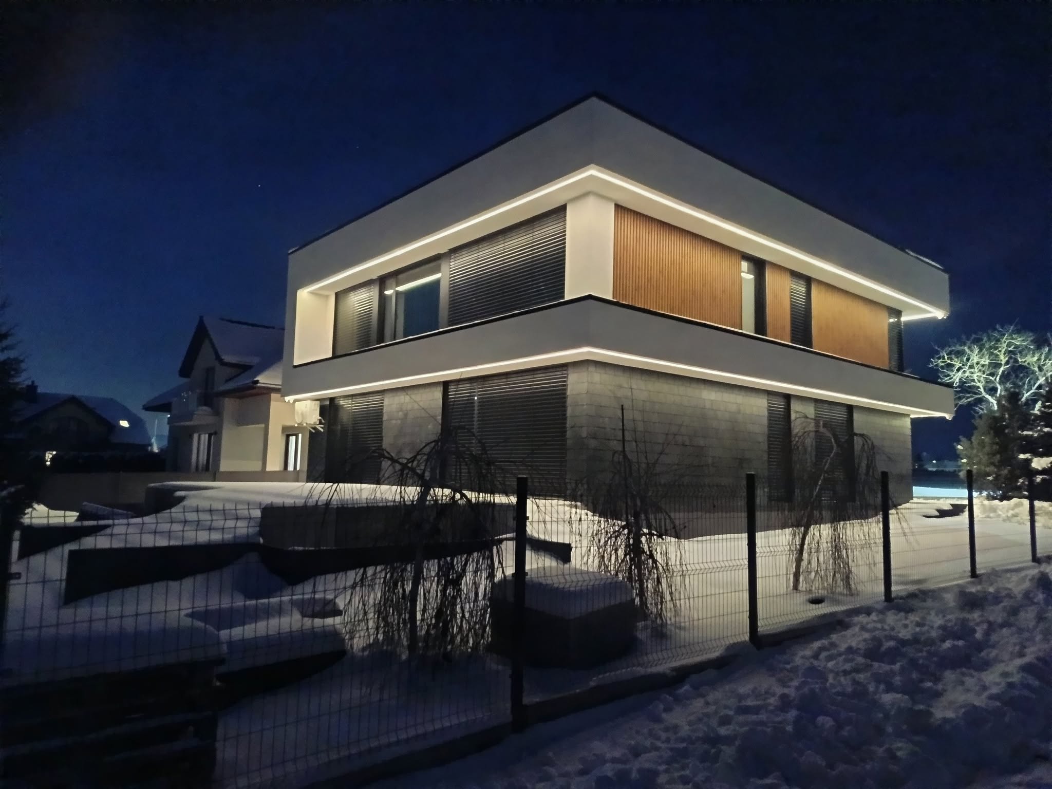 Nowoczesny dom z elewacją premium i liniowym oświetleniem LED nocą