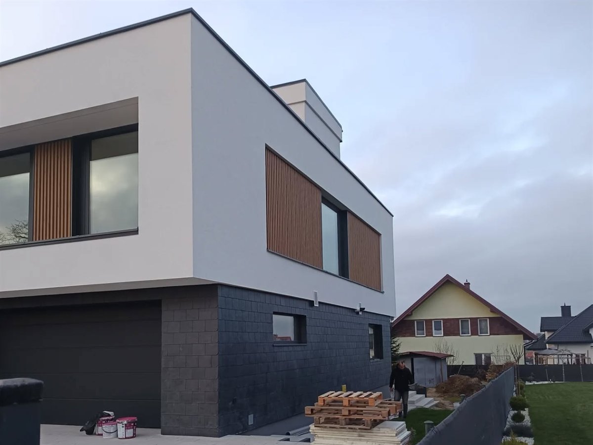 Nowoczesna elewacja z grafitową strefą parteru i drewnopodobnymi lamelami